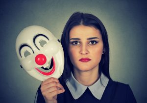 woman holding mask representing 'social mask'