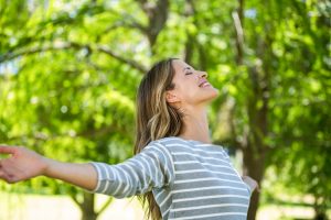 woman with arms stretched out enjoying the summer sun