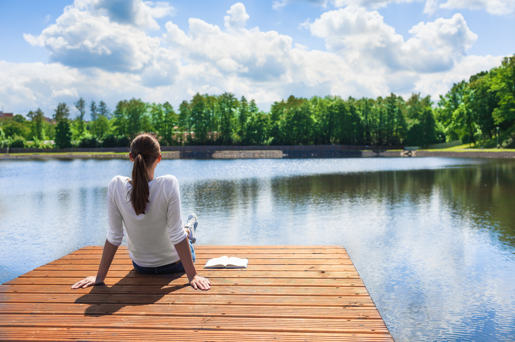Woman prioritizing herself by relaxing by the lake